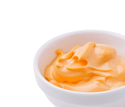 Creamy orange sauce in a white bowl with smooth texture and shine photo