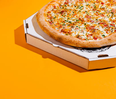 Freshly baked pizza in an open box on a bright surface photo