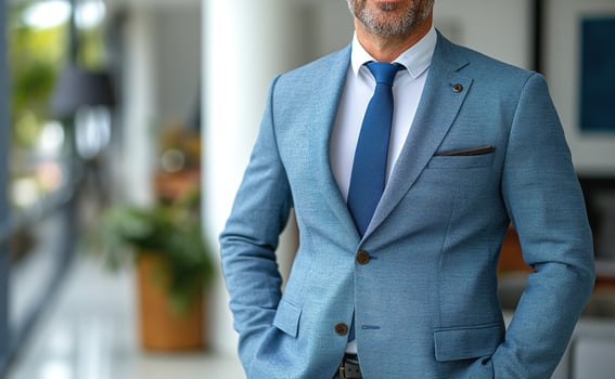 A confident middle-aged Caucasian man in a stylish blue suit, exuding professionalism and charisma in a modern office setting. photo