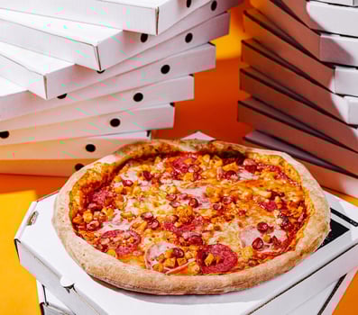 Delicious pizza on a bright orange background with pizza boxes photo