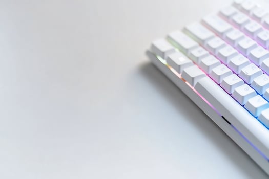White keyboard with rainbow lighting on white surface photo