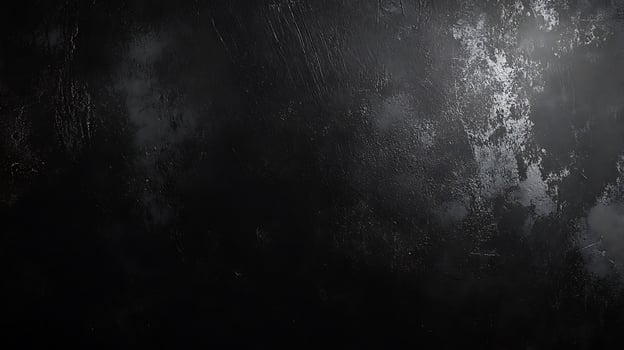 A textured dark surface with subtle gradients of black and gray reminiscent of a weathered material under dim lighting photo