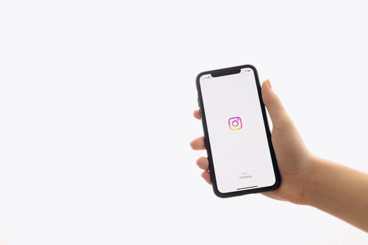 Zaporizhia, Ukraine - January 10, 2025. A woman holds an iPhone with the Instagram app logo on the screen while using a mobile app for business at home. white background photo