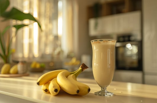 Banana milk in glass. Sweet fruit drink. Fresh smoothie dessert. Healthy cocktail beverage. Homemade banana juice. Natural yogurt milkshake photo