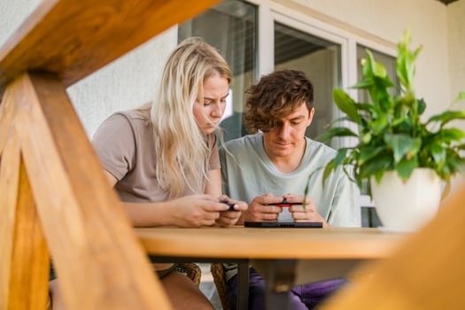 Joyful man and woman playing games on terrace. Technology and game console concept photo