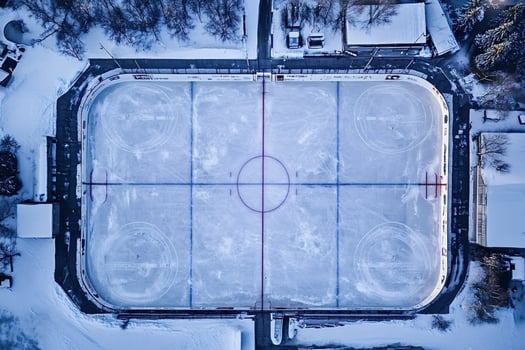 Empty outdoor ice hockey rink covered in snow in winter photo