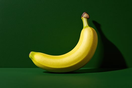 A ripe yellow banana on a dark green background photo