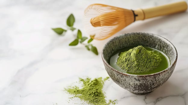 serene matcha preparation scene featuring bowl of vibrant green matcha powder, bamboo whisk, and fresh leaves, evoking tranquility photo
