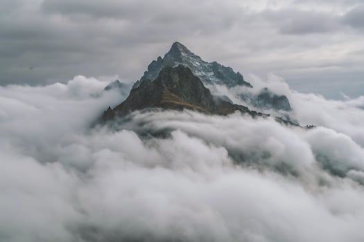 Majestic Mountain Peak Piercing Through a Sea of Clouds Dramatic Landscape Photography photo