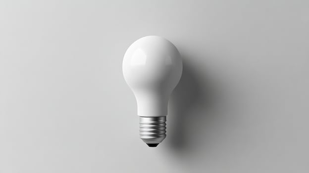 A white light bulb on a gray background photo