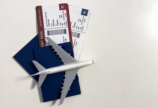 Boarding pass, passport and toy aircraft on desk top view photo