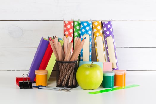 Set of school supplies on white table, front view photo