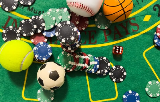 Conceptual background of online sports betting with objects representing different sports, money and chips to bet. Front view. photo