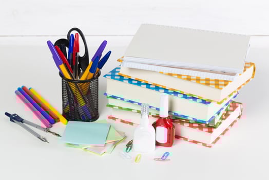 Set of school supplies on white table, front view photo