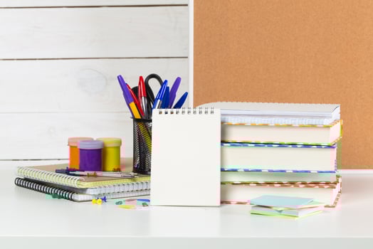 Set of school supplies on white table, front view photo