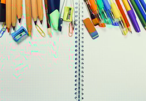 Colorful stationery and supplies organized on a blank notebook page in a study environment photo