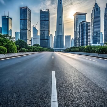 Modern Cityscape Skyline with a Smooth Asphalt Road Leading Towards the Tall Buildings at Sunrise photo