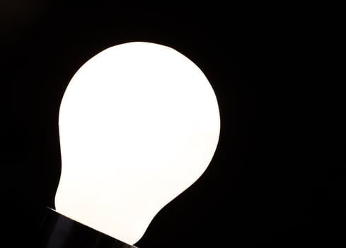 Close-up of electrical bulb on black background photo