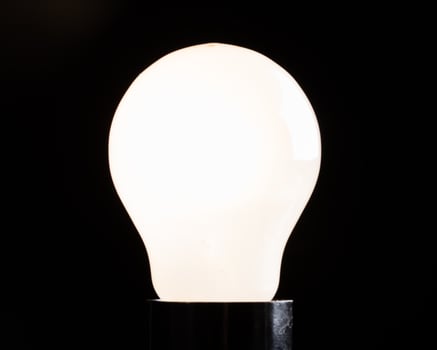 Close-up of electrical bulb on black background photo