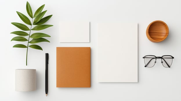 A white and brown notebook sits on a table with a pencil, a pair of glasses photo