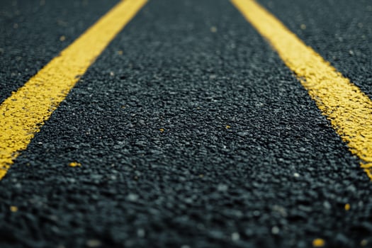 Close Up of Asphalt Road with Yellow Center Lines for Transportation and Travel Concepts photo