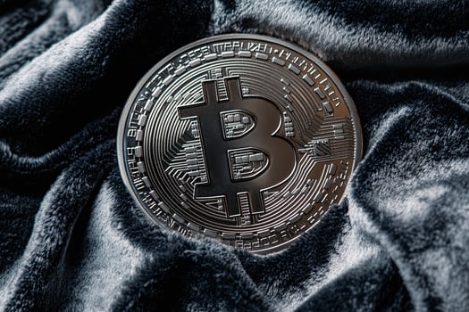 Closeup of Silver Bitcoin Cryptocurrency Coin on Luxurious Dark Grey Velvet Background for Digital Finance Concepts photo