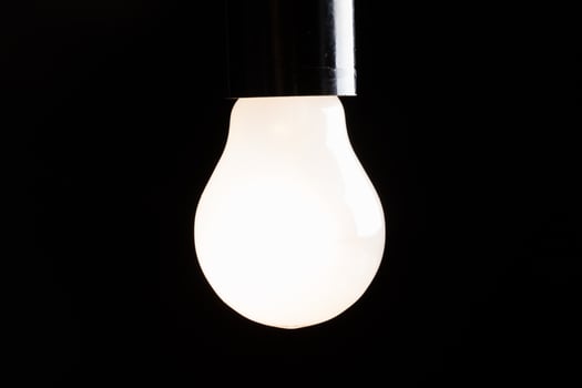 Close-up of electrical bulb on black background photo