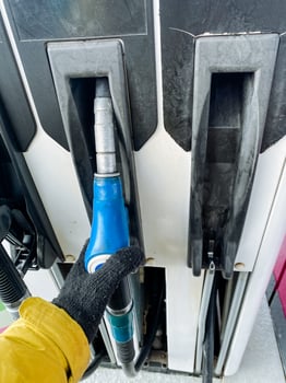 A person is currently engaged in the action of pumping gasoline into a gas pump at a filling station. This machine plays a crucial role in fuel dispensing at service stations photo