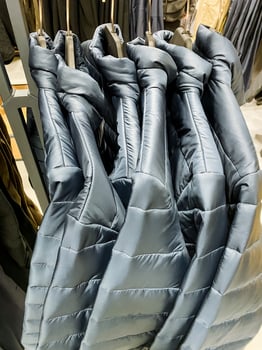 A diverse collection of jackets hangs neatly in a retail store, showcasing different styles and materials for customers to explore and choose according to their preferences photo