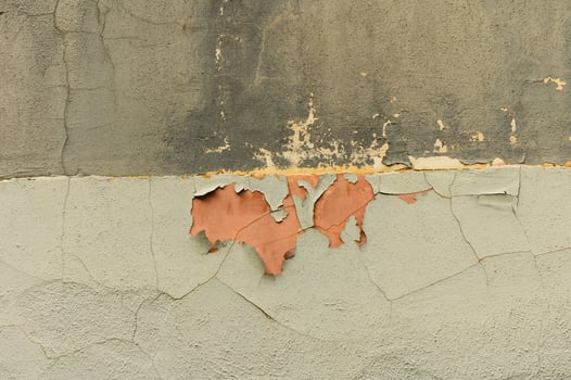 Peeling paint reveals layers of history on a weathered wall in an old urban setting photo