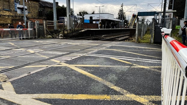 London, UK - March 02, 2025- Railway Crossing Near Enfield Station in London With People and Barriers Visible photo