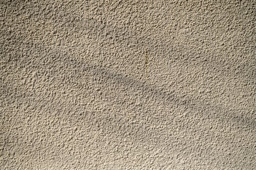 Textured wall illuminated by soft sunlight, showcasing intricate patterns and subtle shadows photo