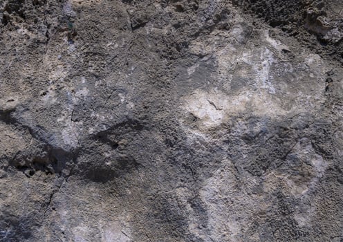 Texture of ancient rock formation showcasing layers in sunlight at midday photo