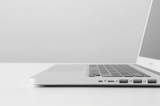 A sleek silver laptop viewed from the side, showcasing its minimalist design and multiple ports. photo