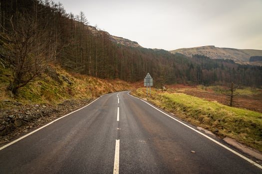 Winding mountain road disappearing into the horizon in Wales photo