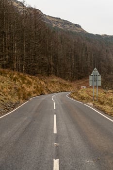 Winding mountain road passing through a forest in United Kingdom photo