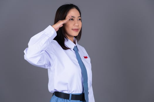 Indonesian Female High School Student in Uniform Hand Salute Gesture Background photo