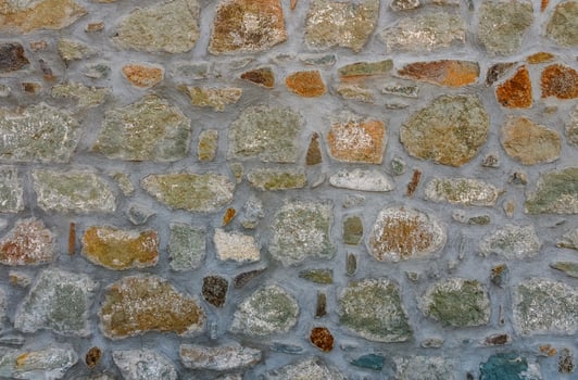 Exploring textures and colors of an ancient stone wall in a quaint village during golden hour photo