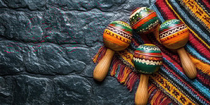 Colorful maracas and a vibrant textile placed on a textured stone surface evoke a festive atmosphere photo