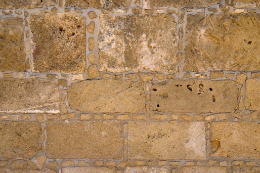 Texture of aged stone wall with warm tones and intricate details from a historic building photo