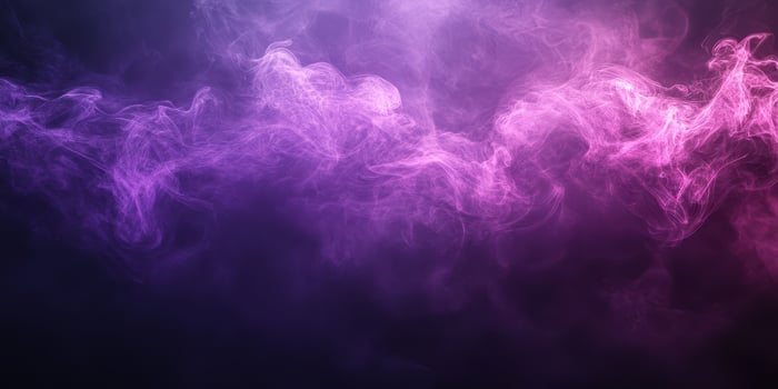 Colorful smoke waves swirl mysteriously in the darkness creating an ethereal atmosphere photo