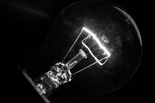 Close-up of electrical bulb on black background photo