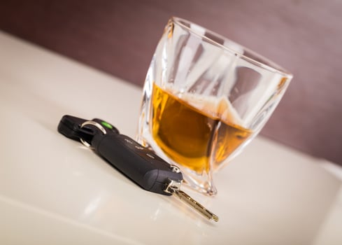 Glass with cognac or whiskey and car keys on table photo