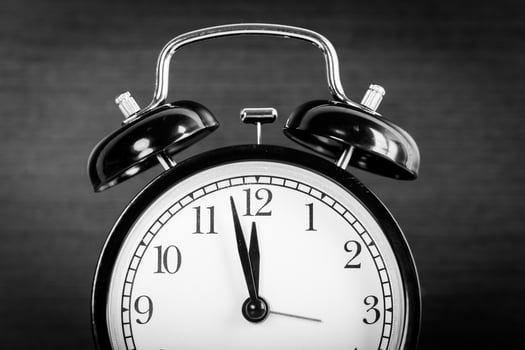 Alarm clock on brown wooden background close up photo