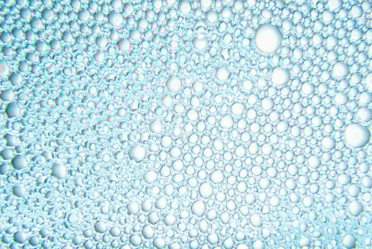 Texture of soap bubbles with water with blue light photo