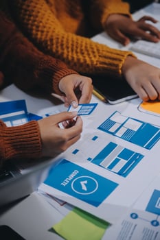A group of people working on a project with blue and white papers photo