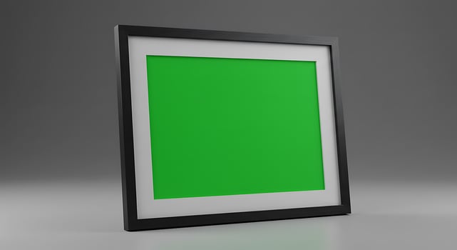 A green screen in a black frame on a gray background photo