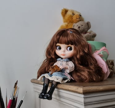 Handmade doll sitting on wooden shelf photo