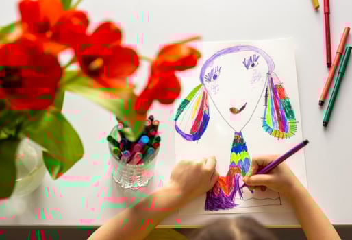 Close-up of girl's hands draw a portrait of mom photo