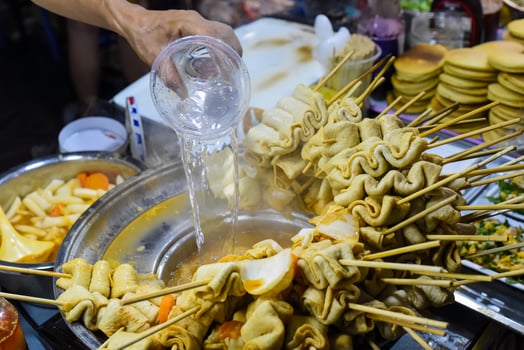 Hand adding water in bouillion for Korean fish cakes photo